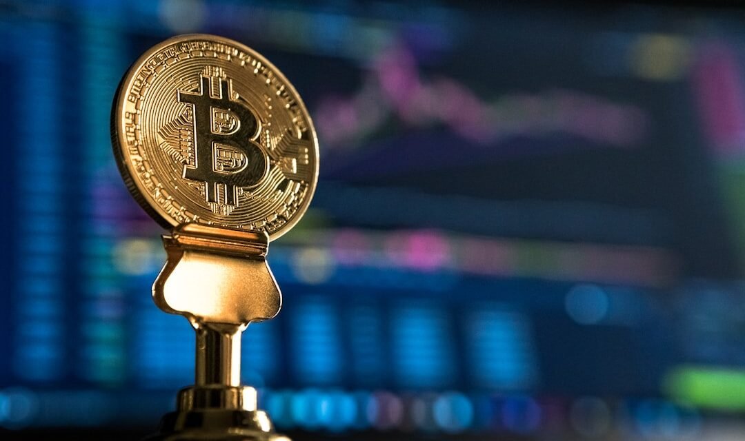 Bitcoin coin near a rising price chart on a monitor, representing technical analysis