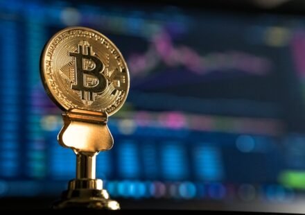 Bitcoin coin near a rising price chart on a monitor, representing technical analysis