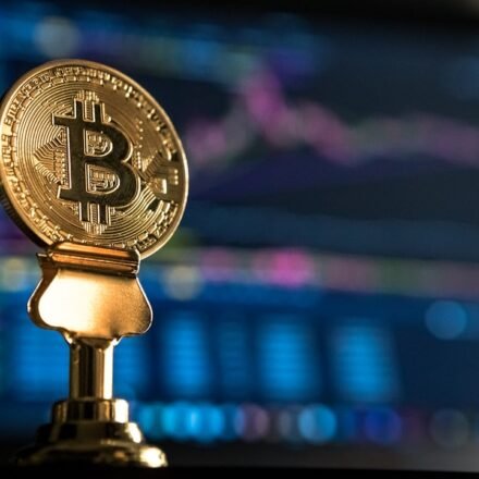 Bitcoin coin near a rising price chart on a monitor, representing technical analysis